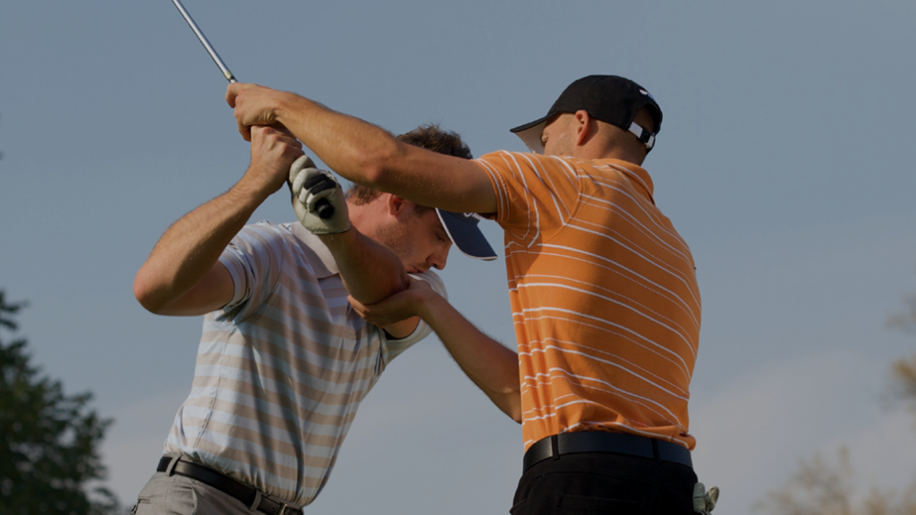 Golfer receiving instruction on golf course